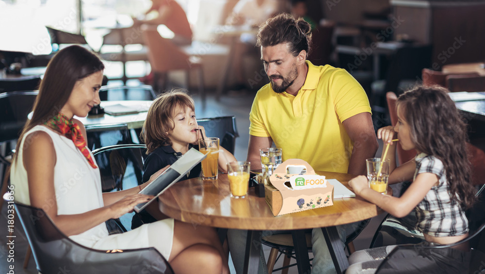 Una famiglia al tavolo di un ristorante convenzionato con il progetto reFood e le scuole